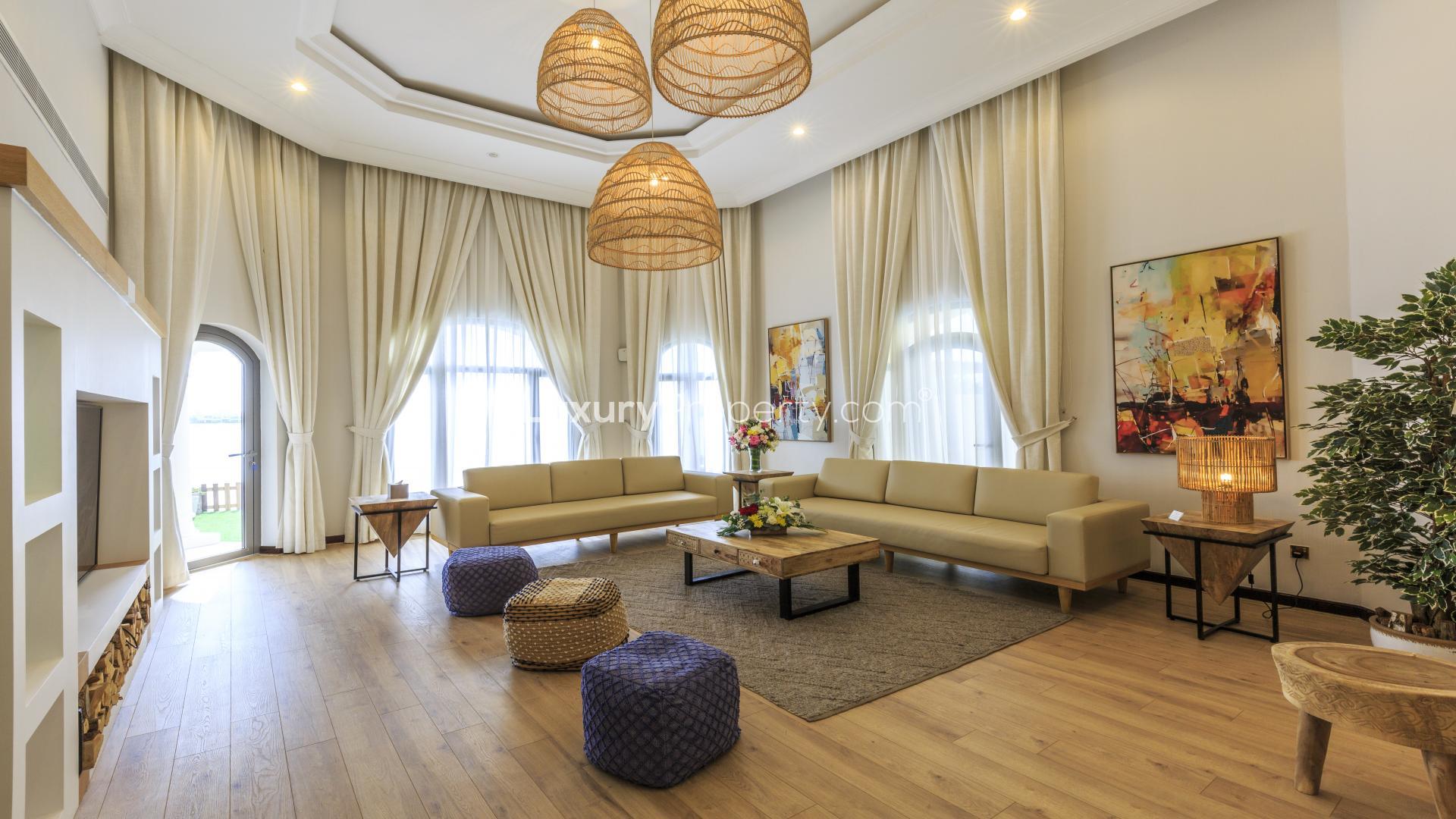 "Elegant hallway with decor in Palm Jumeirah villa, featuring large mirror and art.",Luxurious living room in upgraded Palm Jumeirah villa with modern decor and natural light