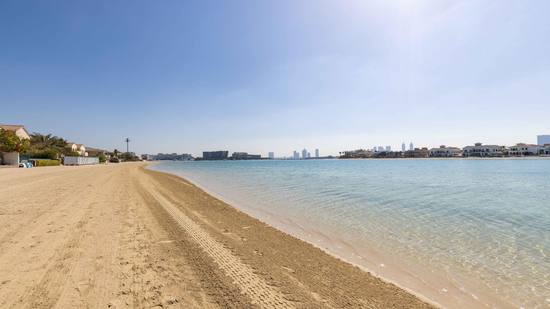 Dining room in furnished Palm Jumeirah villa with vibrant parrot artwork and waterfront view