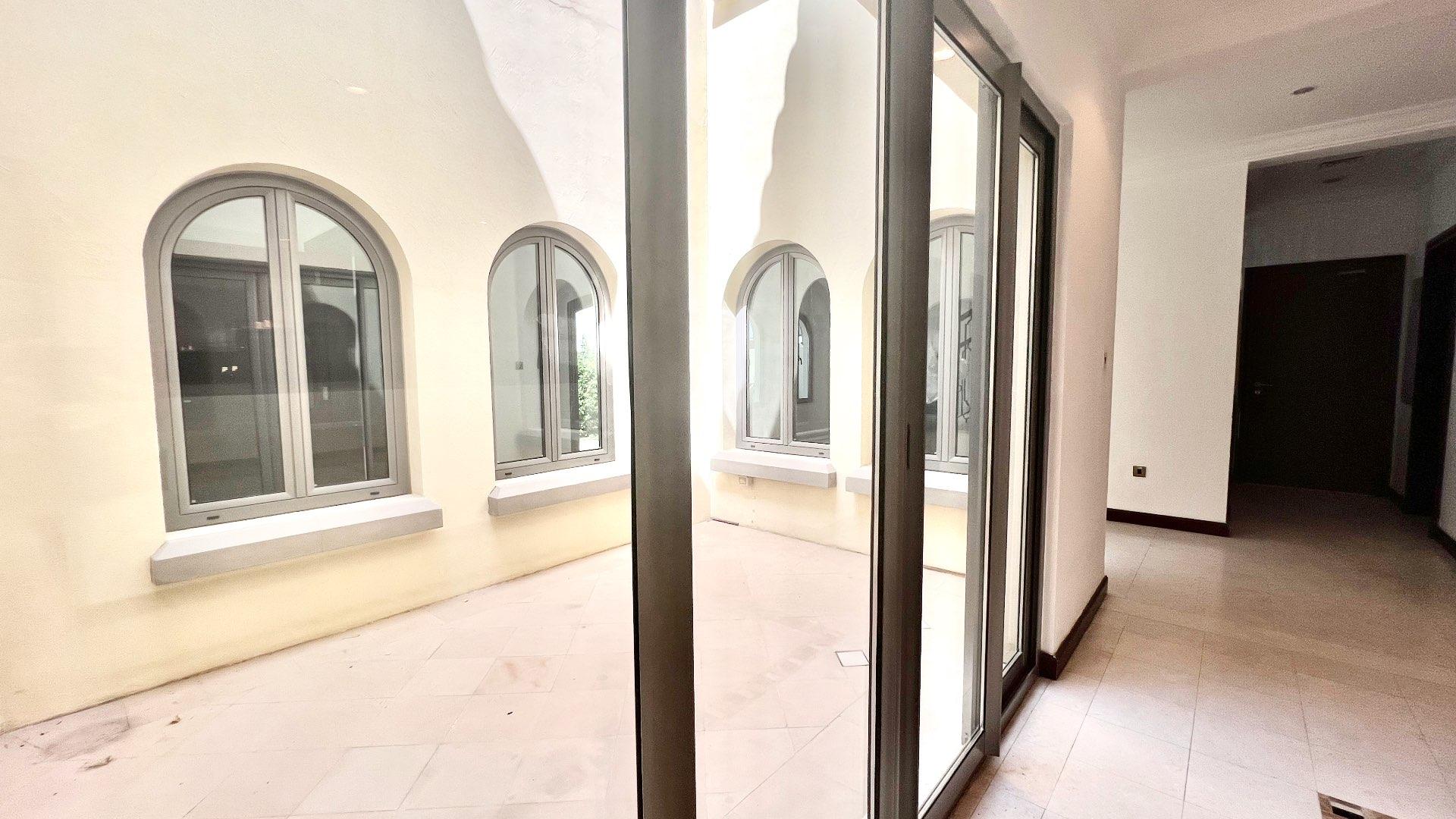 Spacious living room in Palm Jumeirah villa with elegant chandeliers and large windows