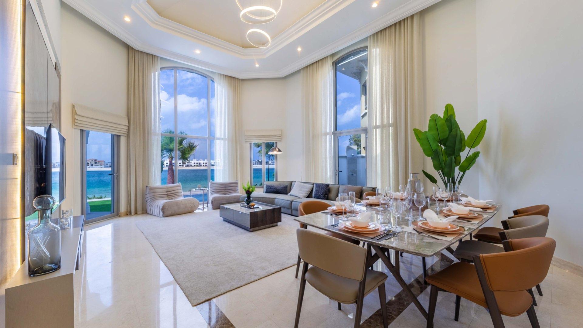"Luxurious 4-bedroom villa exterior with landscaped garden in Palm Jumeirah, Garden Homes.",Luxurious living room and dining area in Palm Jumeirah 4-bedroom villa with sea view
