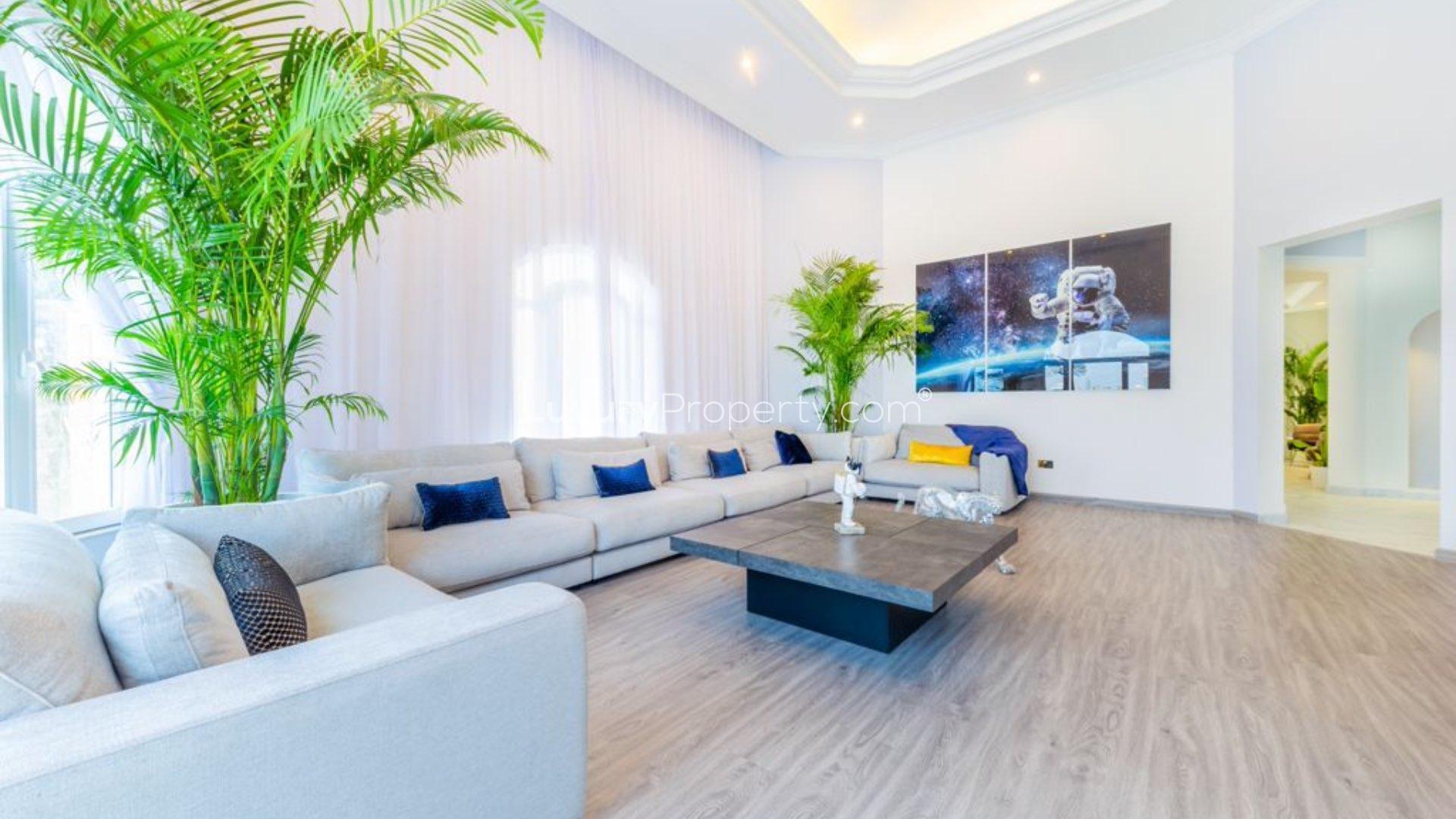 Luxurious Palm Jumeirah villa living room with marina skyline views, elegant decor, and greenery