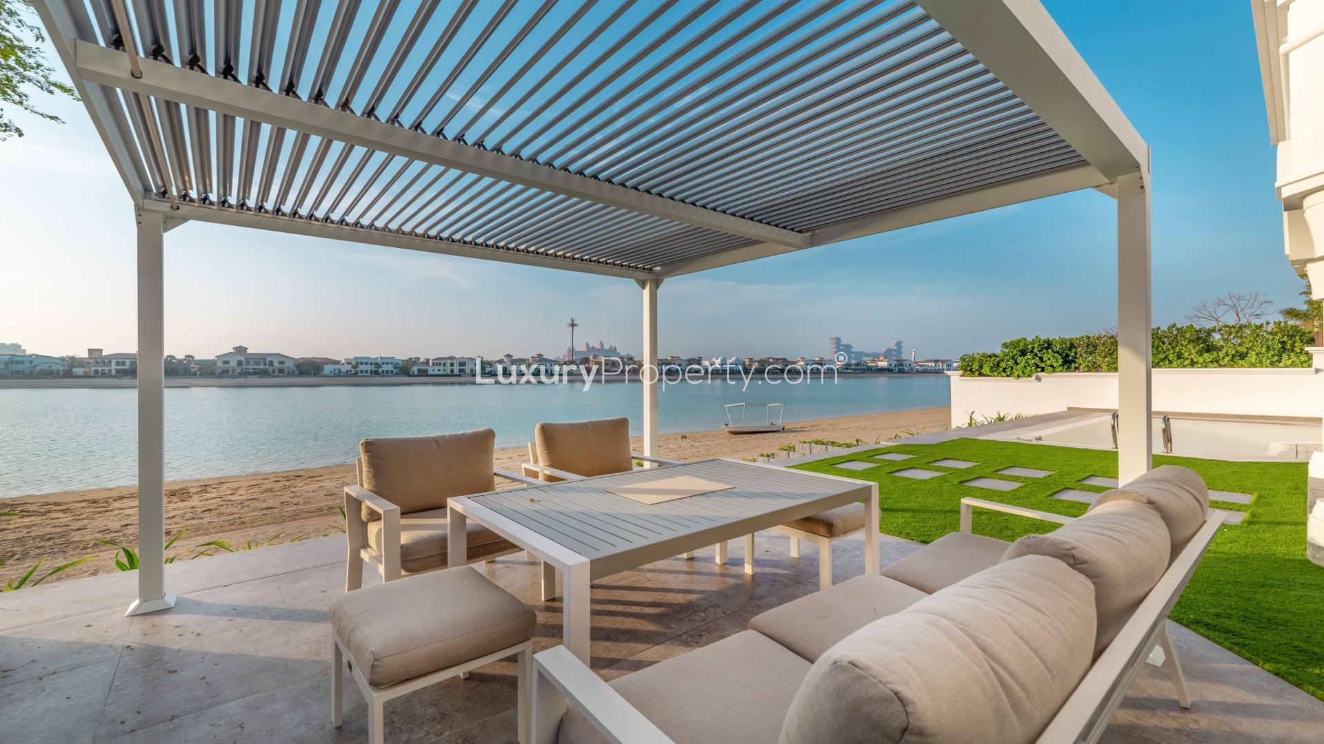 "Luxurious Palm Jumeirah villa exterior with lush garden in Garden Homes community.",Luxury beachfront villa patio with sea view in Palm Jumeirah Garden Homes