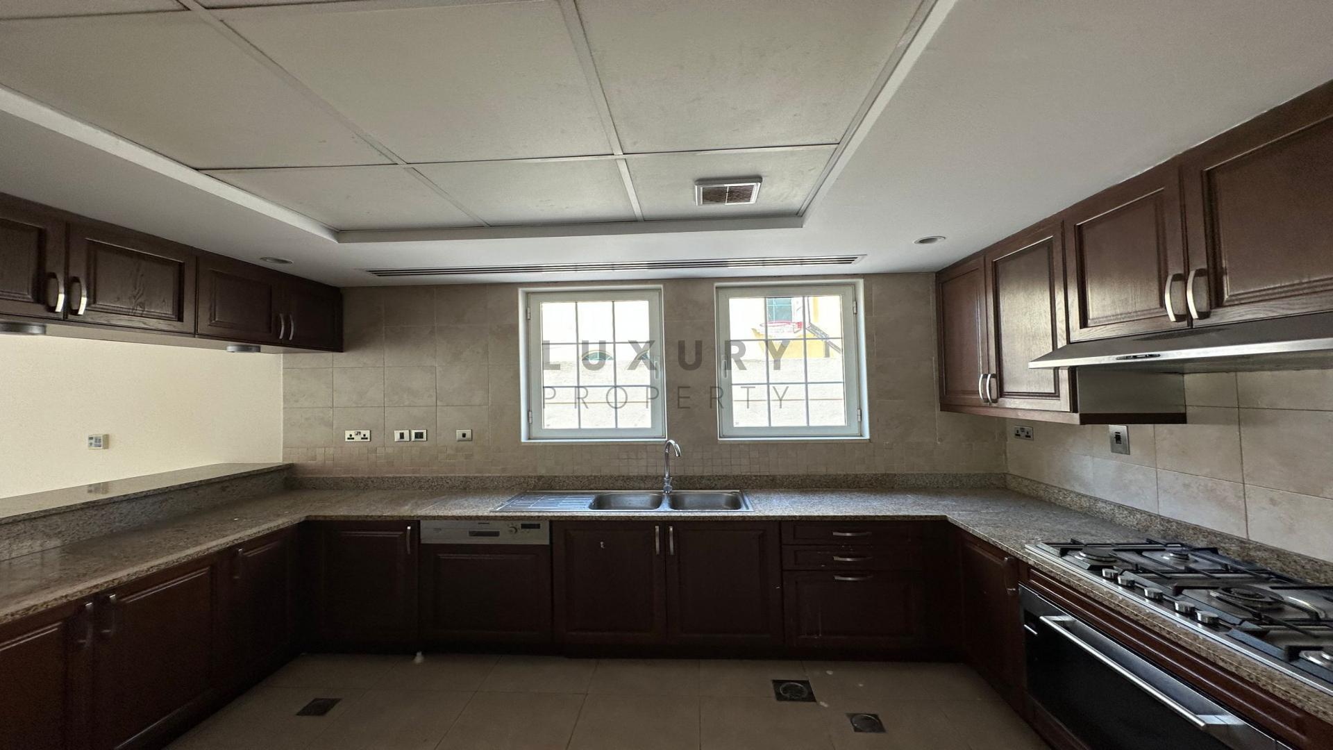 Spacious kitchen with dark wood cabinets in Jumeirah Park Legacy Villa for rent