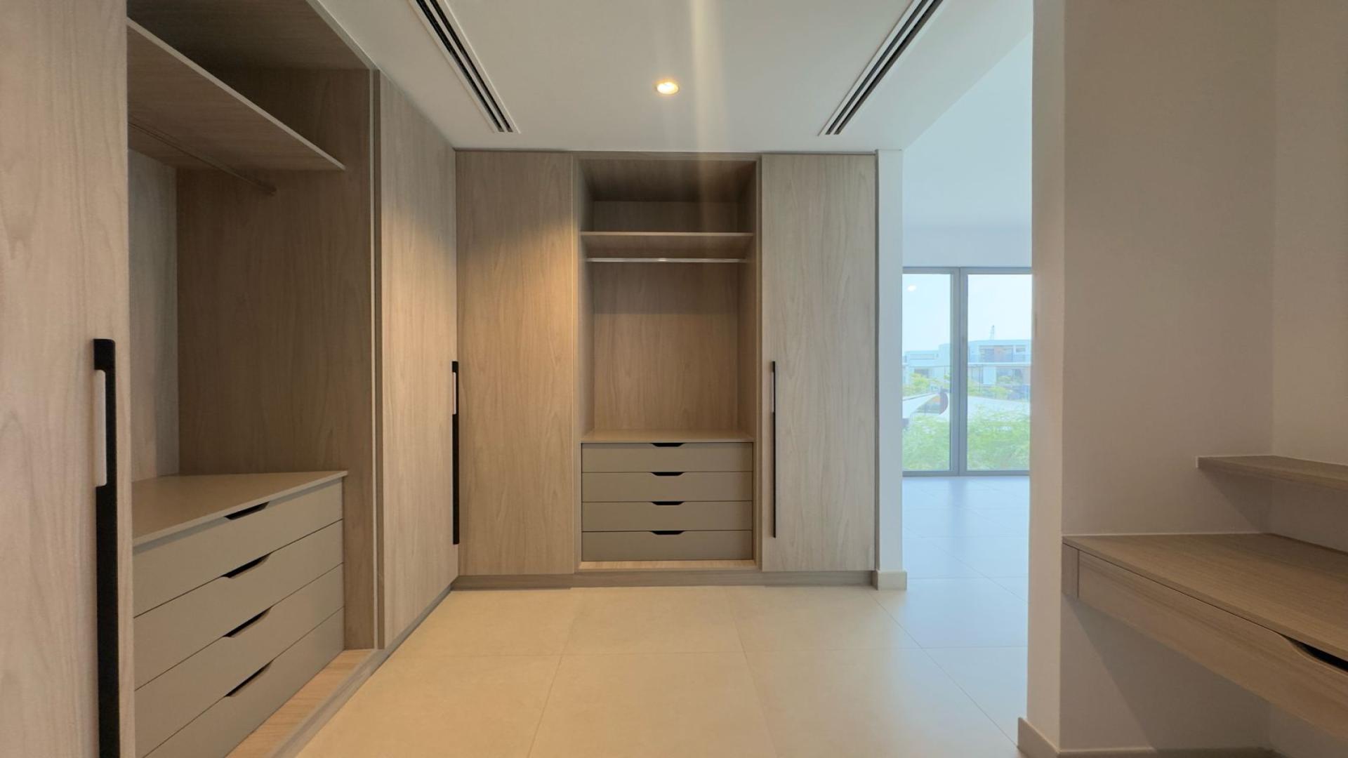 Modern open-plan kitchen and living area in Tilal Al Ghaf villa for rent