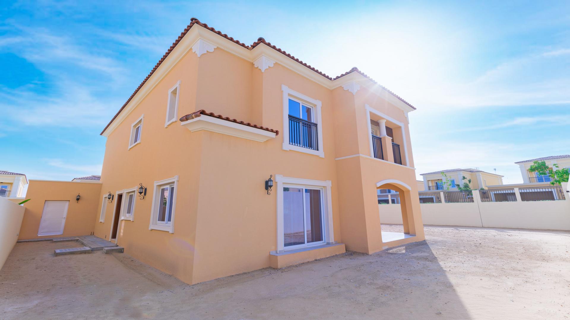 Spacious living room in Villanova villa, Dubai Land, with large windows and tiled floors
