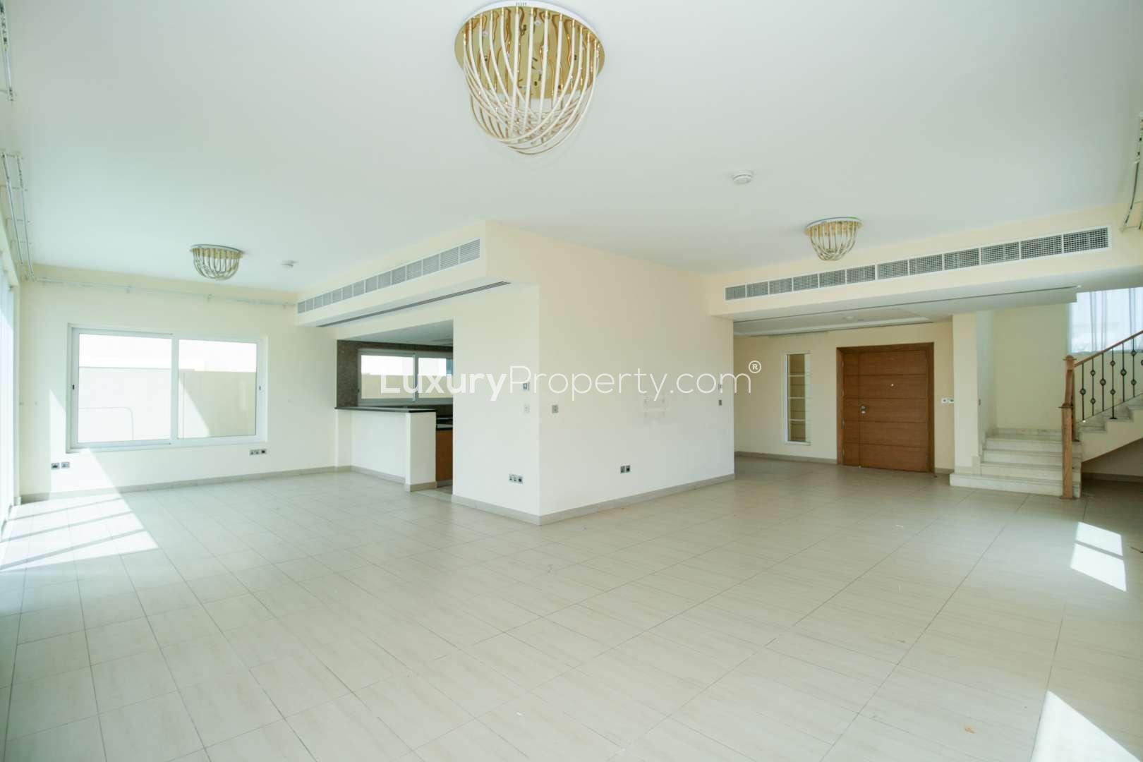 "Spacious living room in 4-bedroom Legacy Nova Villa, Jumeirah Park for sale.",Open-plan living area in Legacy Nova Villa, Jumeirah Park, with staircase and large windows