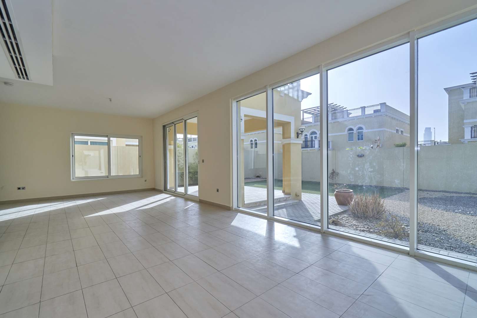 Sunlit living room in 4-bed Nova Villa, Jumeirah Park, with large windows and tiled floor