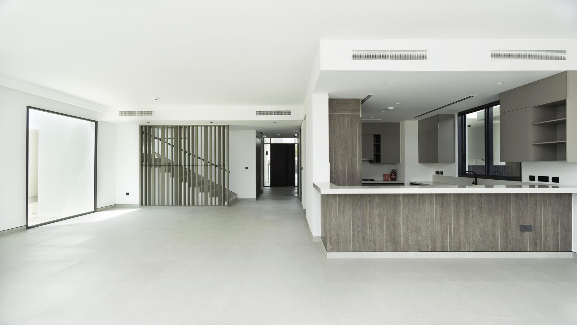 Modern kitchen and spacious living area in Tilal Al Ghaf villa for rent