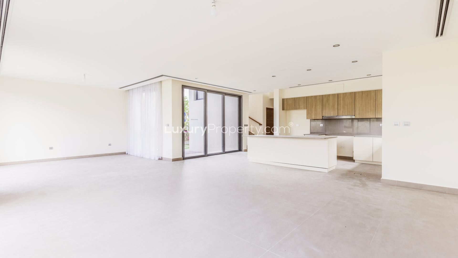 Modern kitchen in 4-bedroom villa, Dubai Hills Estate, with garden views through large windows