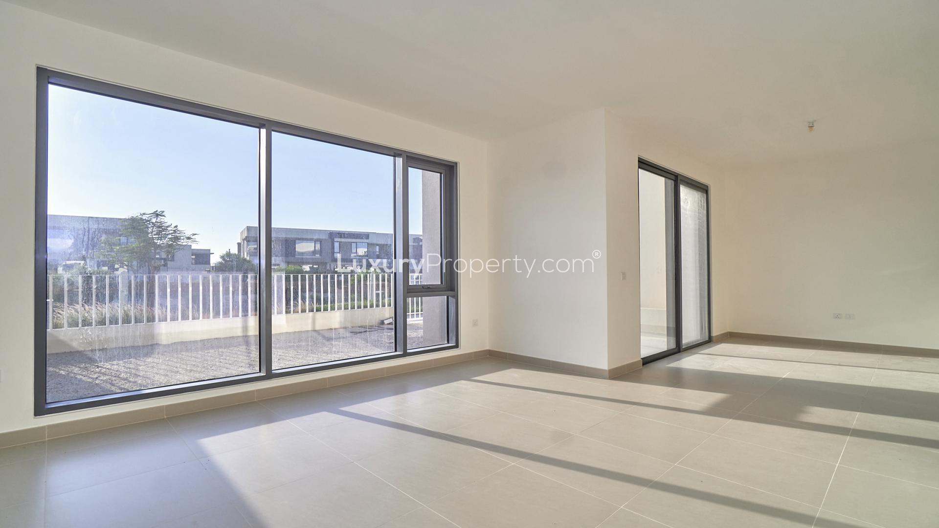 "Modern townhouse exterior in Maple, Dubai Hills Estate, featuring spacious garage and sleek design.",Bright living room with large windows, Maple at Dubai Hills Estate townhouse for rent