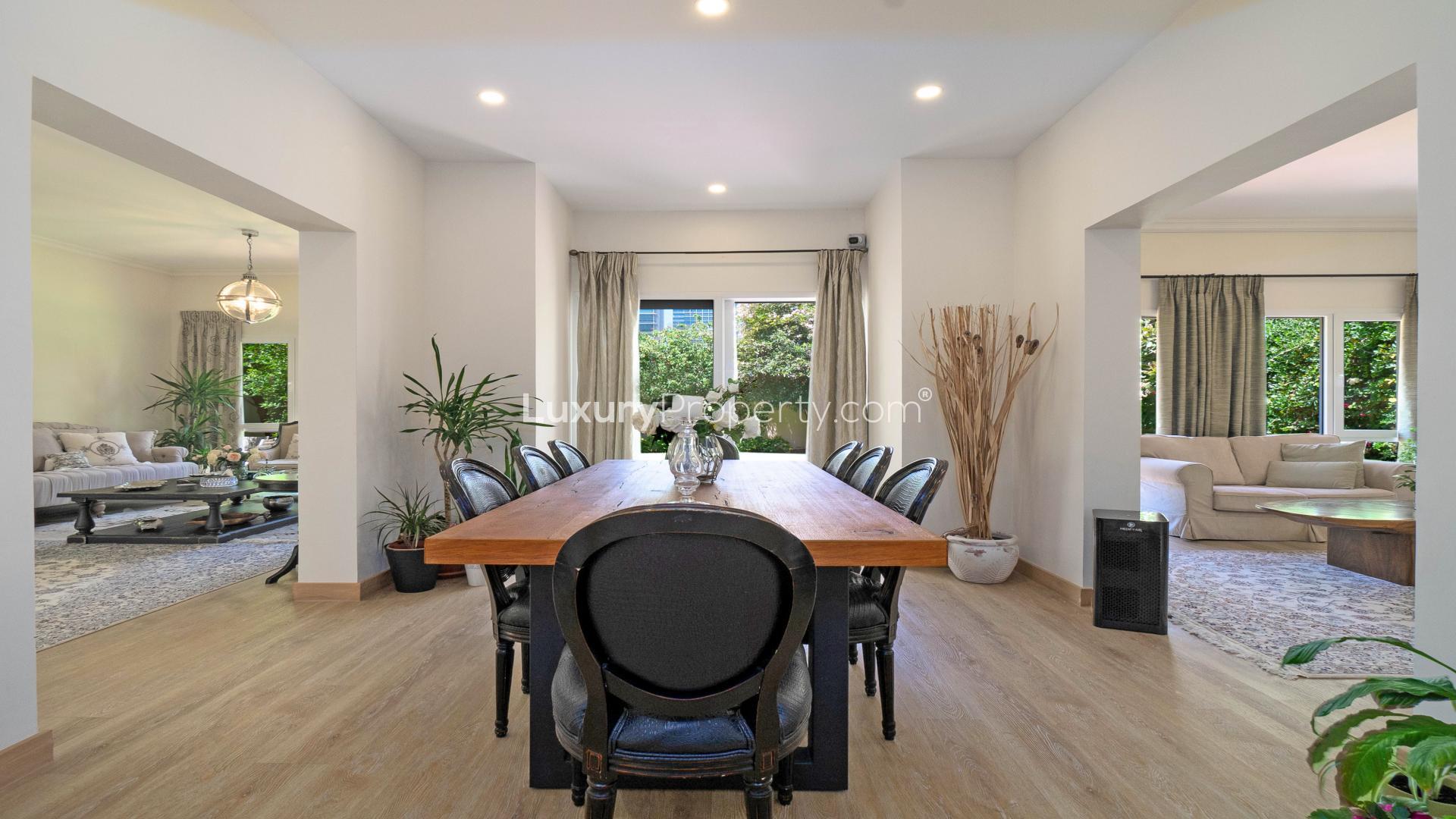 "Stunning 4-bedroom villa with landscaped garden in Meadows 2, Dubai, for rent.",Dining and living area in 4-bedroom villa, Meadows 2, Dubai, with modern decor