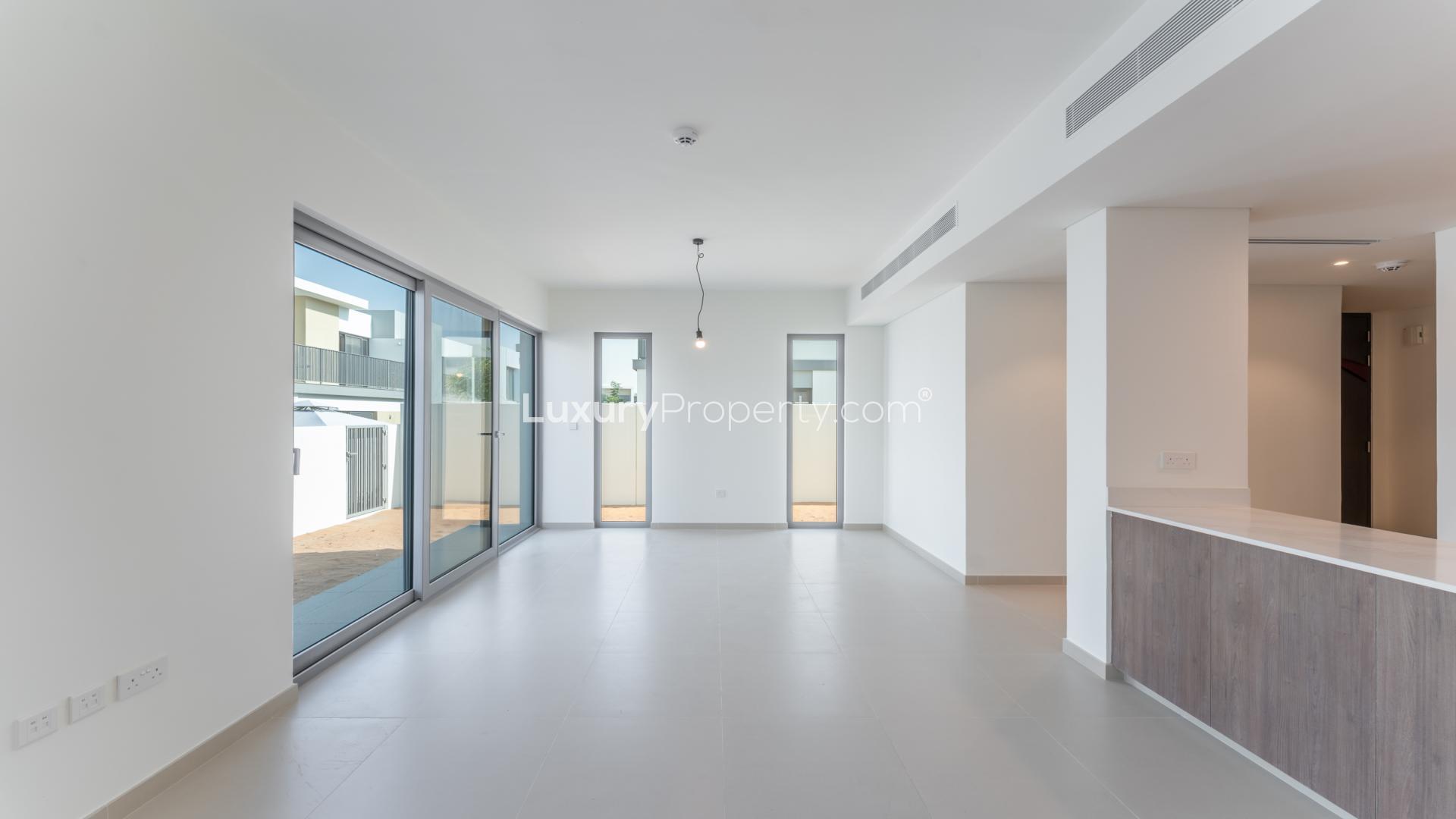 Modern kitchen and living area in Elan villa, Tilal Al Ghaf, with garden view