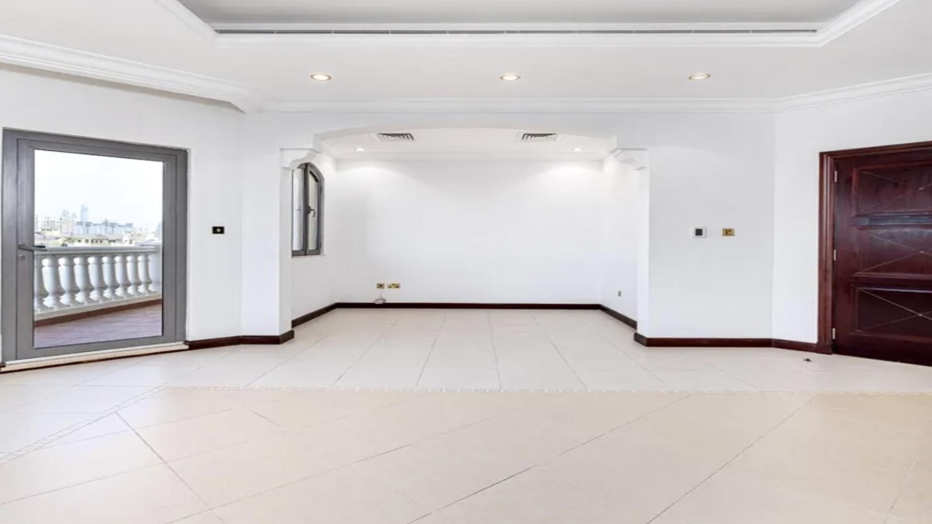 "Spacious living area in beachfront villa for rent, Palm Jumeirah, Garden Homes.",Empty living room with balcony view in Palm Jumeirah beachfront villa for rent