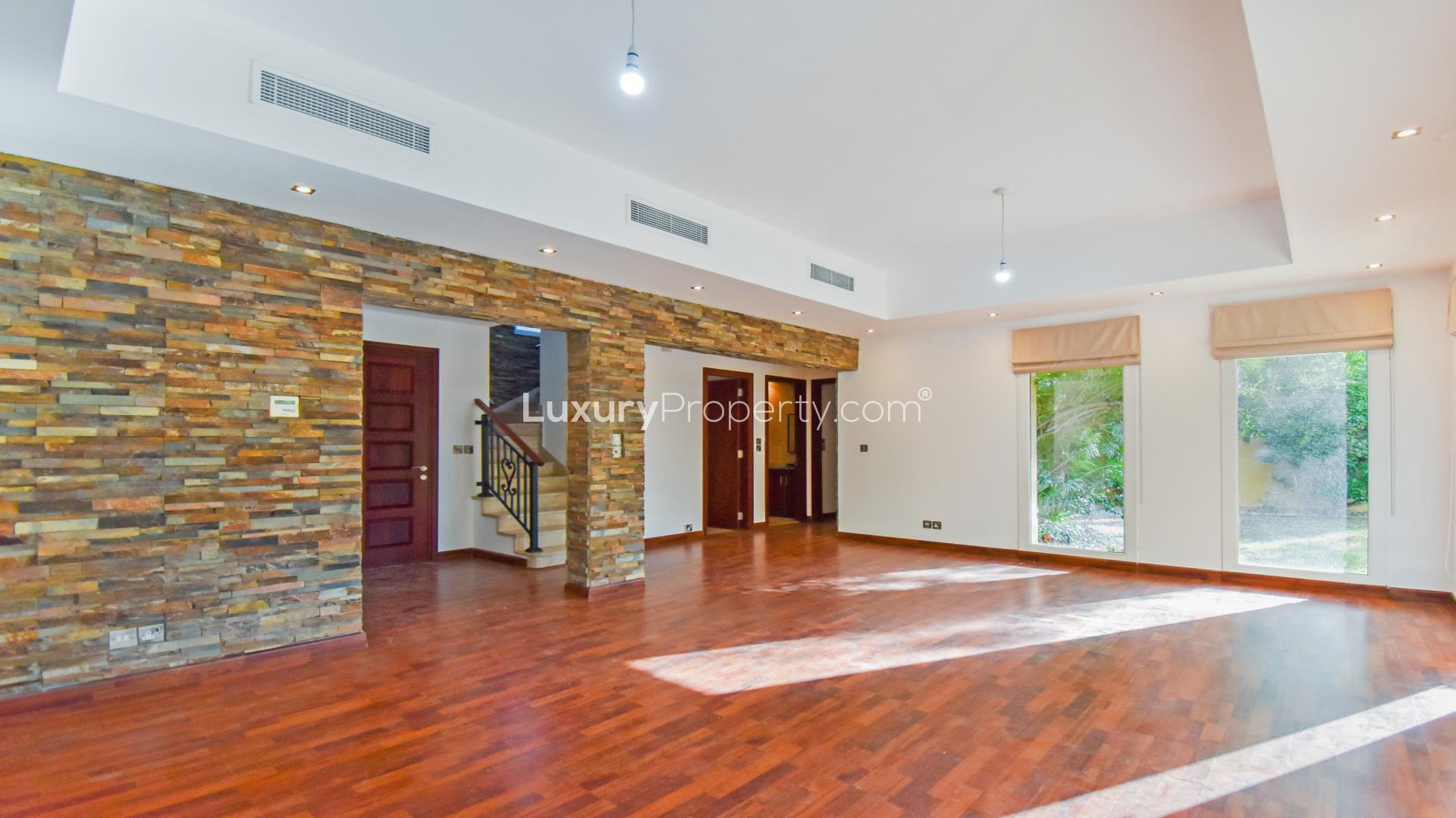 "Spacious living area with wooden flooring in upgraded villa, Arabian Ranches, Palmera.",Bright living room with stone accent wall in Arabian Ranches villa for rent, LP12788