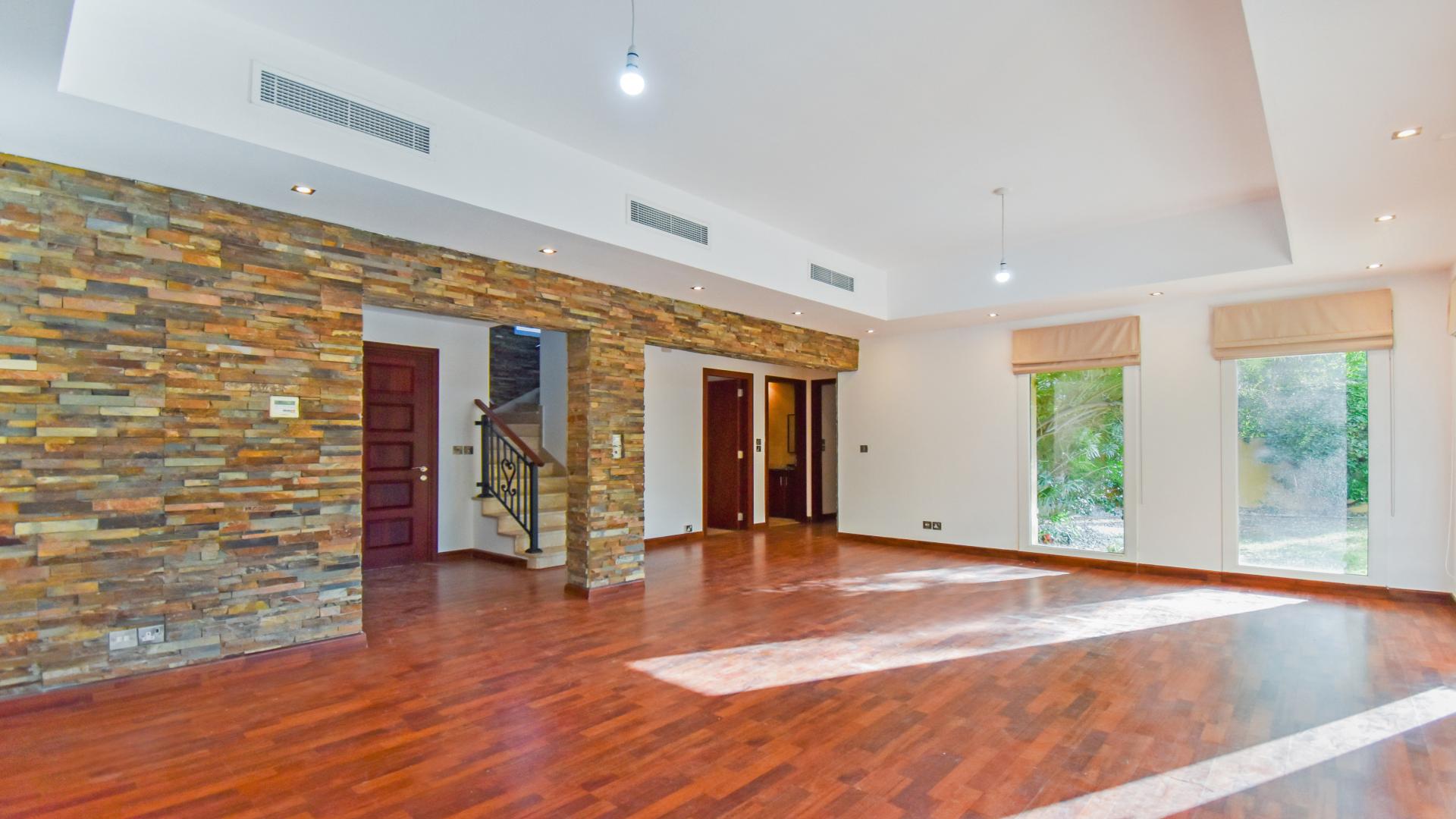 "Spacious living area with wooden flooring in upgraded villa, Arabian Ranches, Palmera.",Bright living room with stone accent wall in Arabian Ranches villa for rent, LP12788