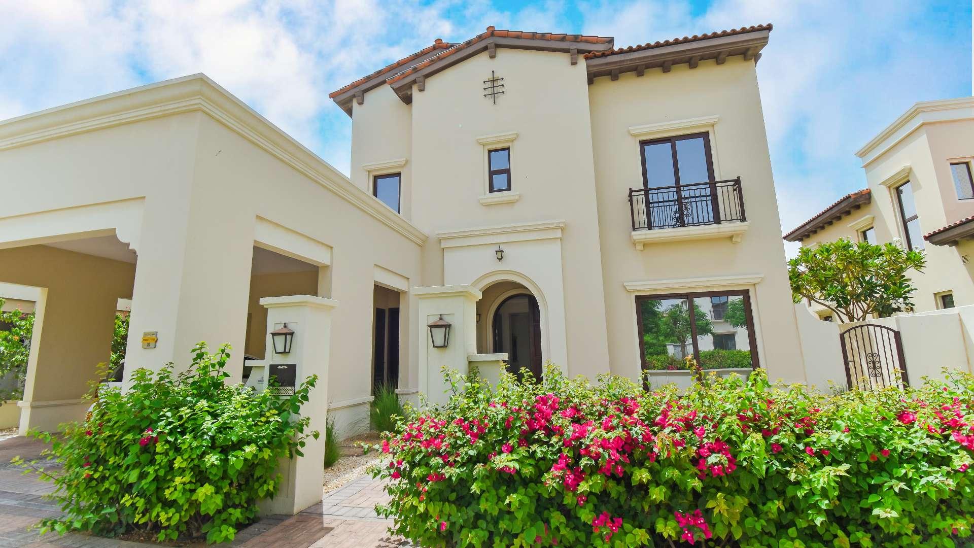 Empty living room in four-bedroom villa, large windows, view of landscaped garden, Arabian Ranches 2