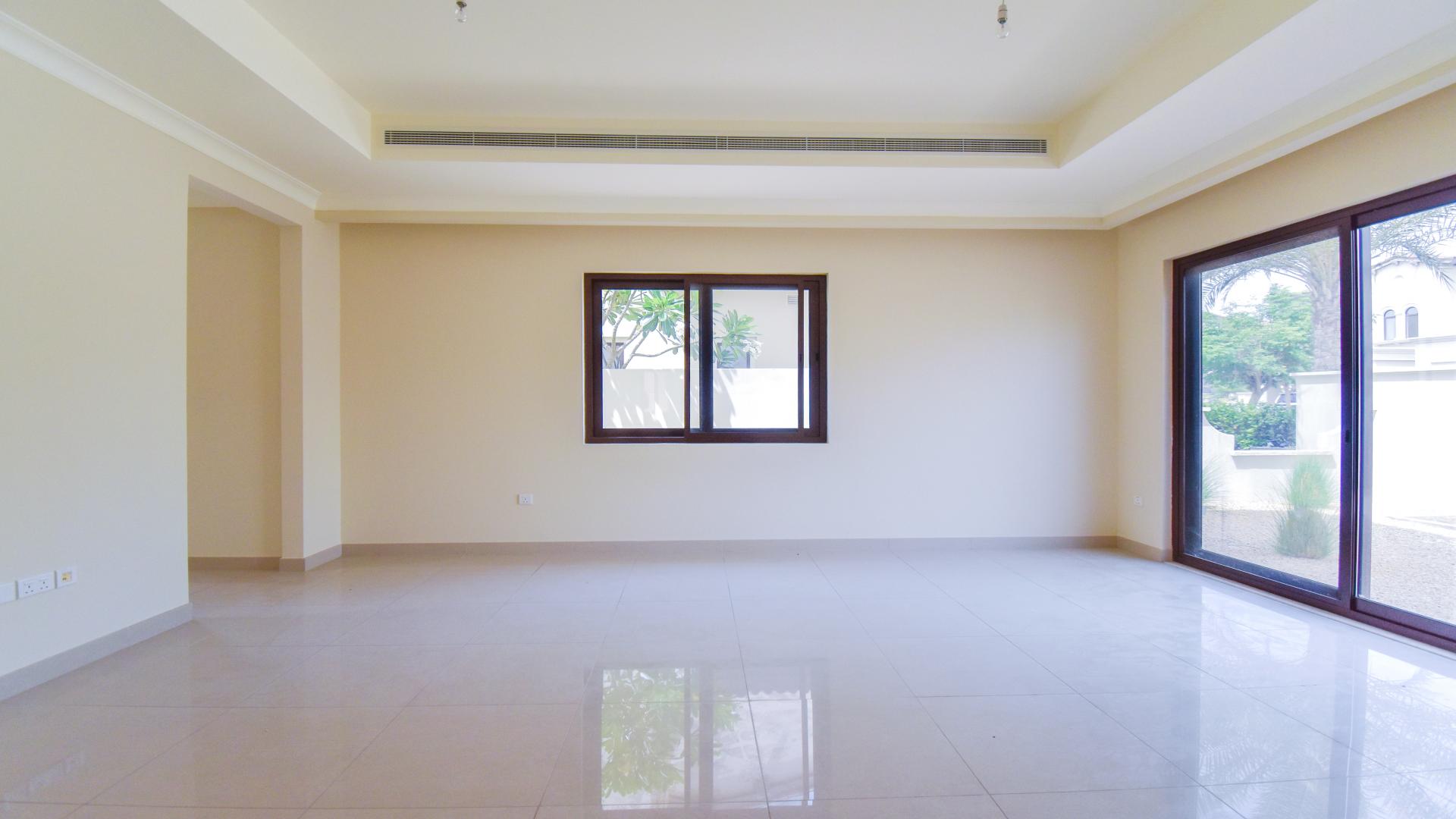 Spacious living room in 4-bedroom villa, Rosa, Arabian Ranches 2, with large windows and garden view