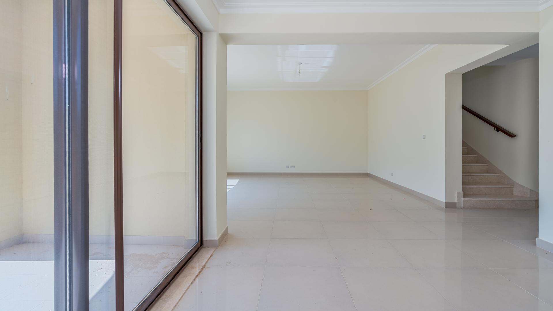 "Spacious living area with staircase in luxurious Samara villa, Arabian Ranches 2 for rent.",Empty living room and kitchen entrance in Samara villa, Arabian Ranches 2, available for rent