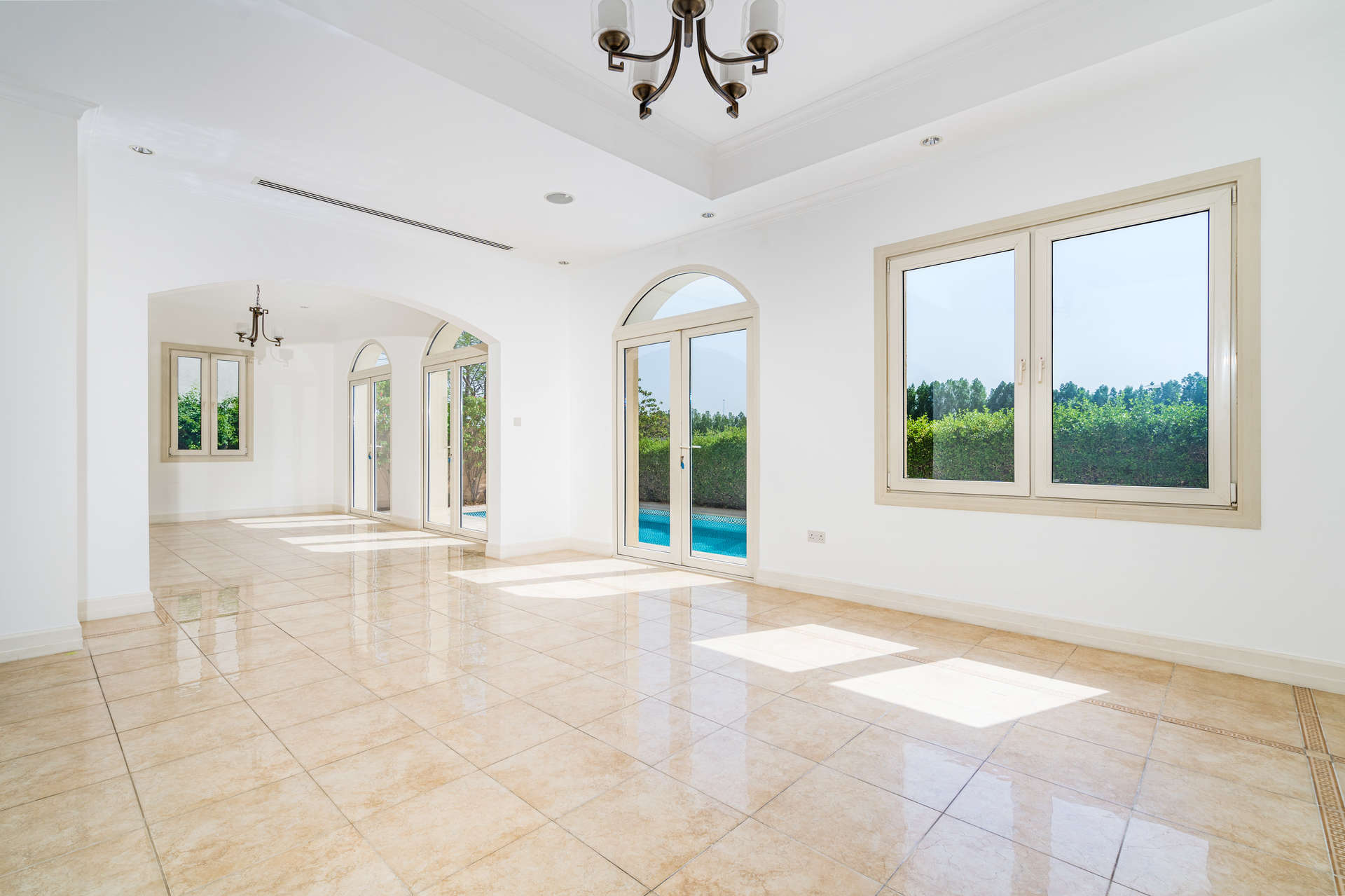 Empty room with tiled floor and arched windows in Sienna Lakes villa, Jumeirah Golf Estates