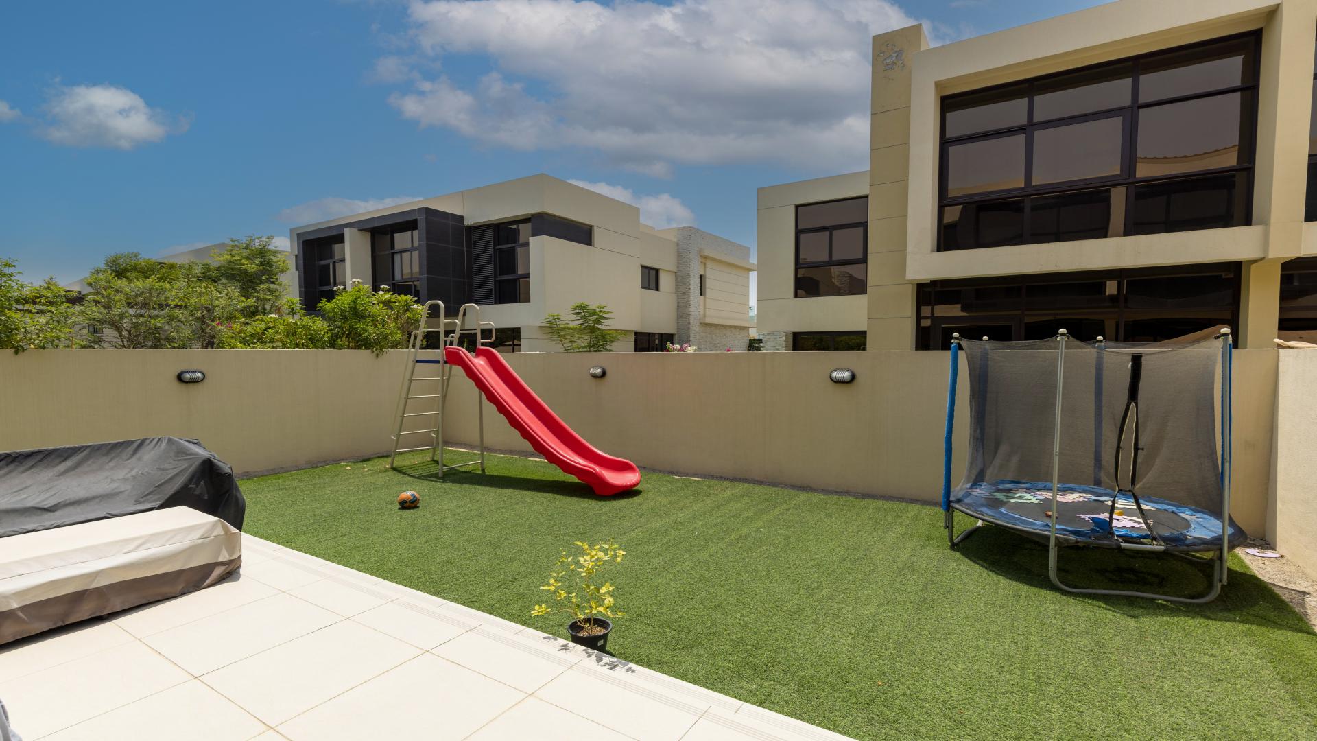 Modern villa living room in Damac Hills, Rochester, with elegant blue sofas and large windows
