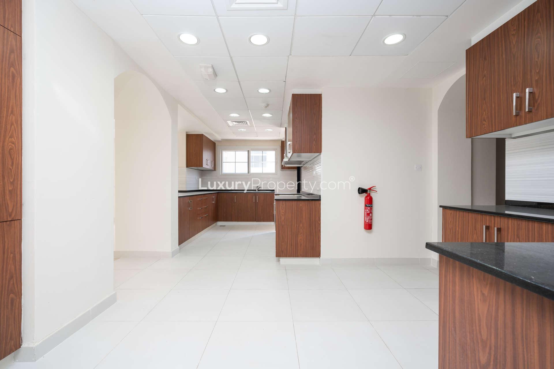 Modern kitchen in 4-bedroom Il Vento Villa, Jumeirah Golf Estates, with wooden cabinets