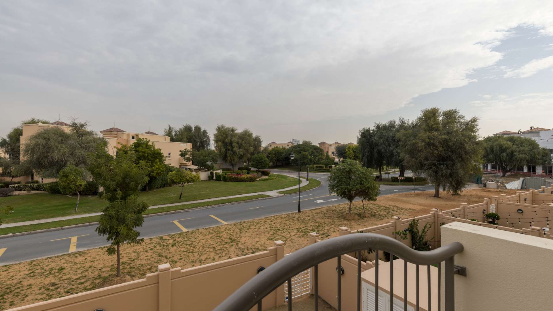 Elegant villa exterior in Victory Heights, Dubai Sports City, with palm trees and archways