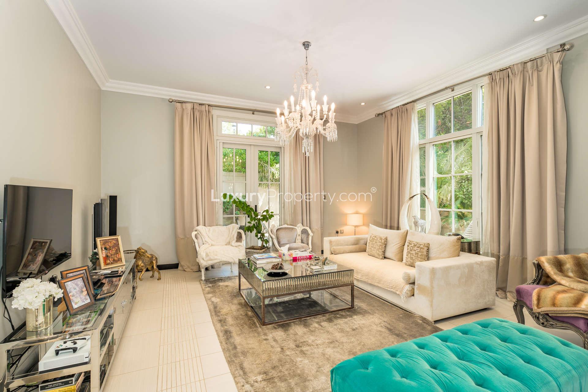"Charming garden and patio of 4-bedroom Sawgrass Villa in Jumeirah Golf Estates, Earth community.",Luxurious living room in 4-bedroom villa, Jumeirah Golf Estates, featuring elegant decor and chandelier