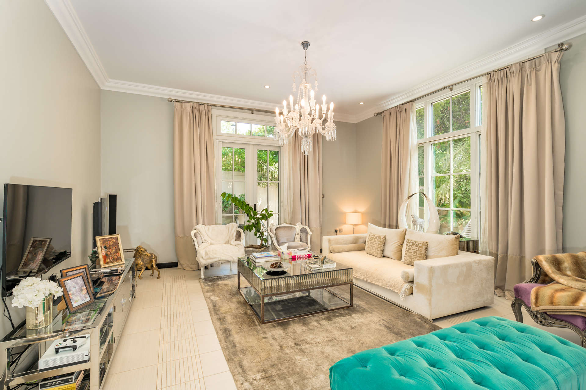 "Charming garden and patio of 4-bedroom Sawgrass Villa in Jumeirah Golf Estates, Earth community.",Luxurious living room in 4-bedroom villa, Jumeirah Golf Estates, featuring elegant decor and chandelier