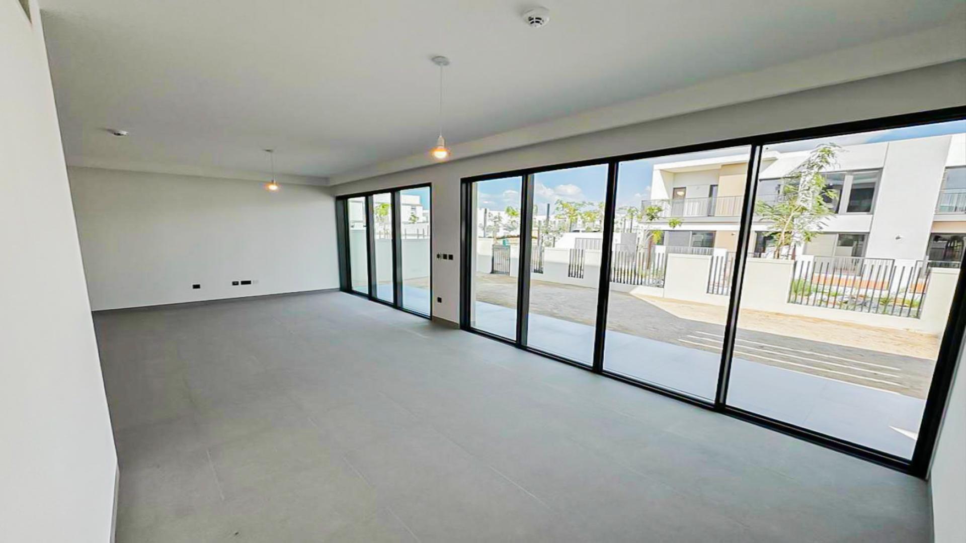 "Spacious living room with large windows in Tilal Al Ghaf villa, Harmony community.",Spacious living room in upgraded Tilal Al Ghaf villa, large windows, modern design