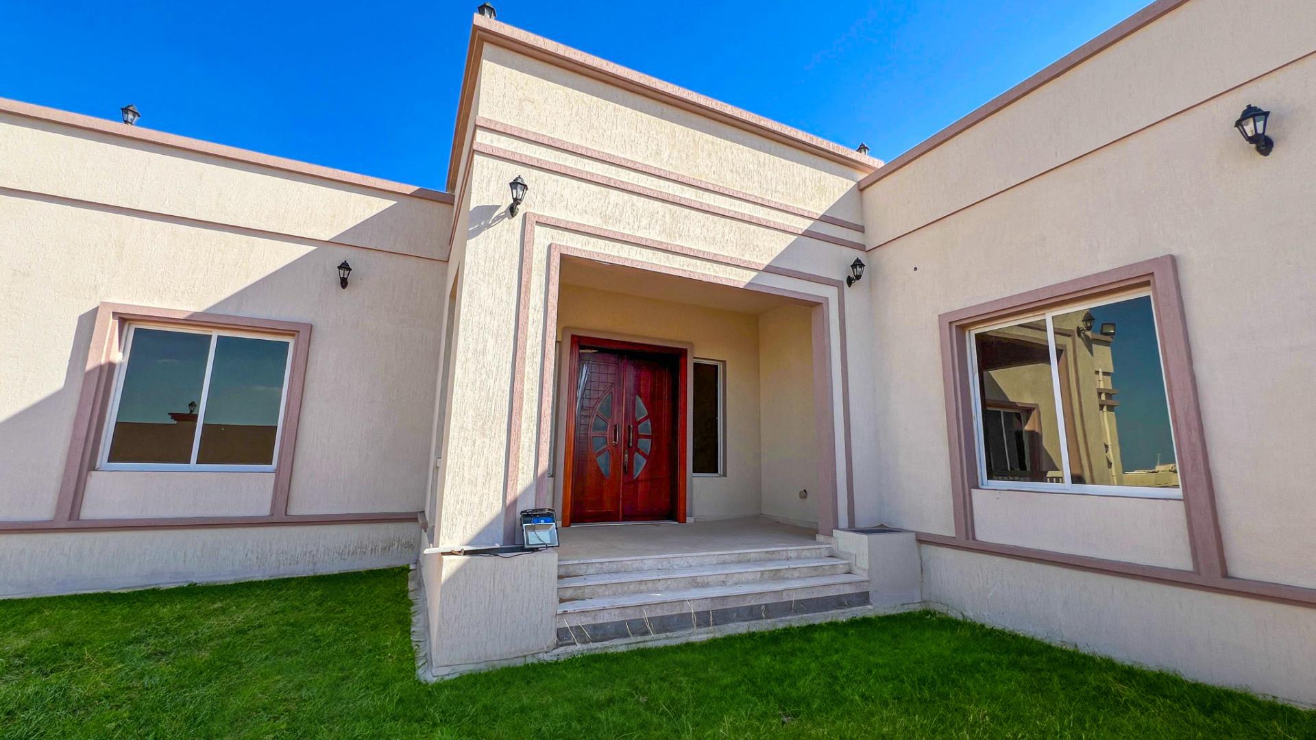 Expansive villa exterior with lush lawn in Al Riffa, RAK, available for sale