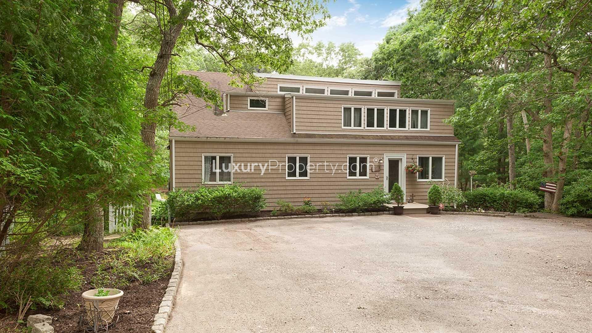 "Charming garden view of luxury villa at 1663 Majors Path, Hamptons, New York.",Luxury four-bedroom villa exterior surrounded by lush greenery in Hamptons, New York