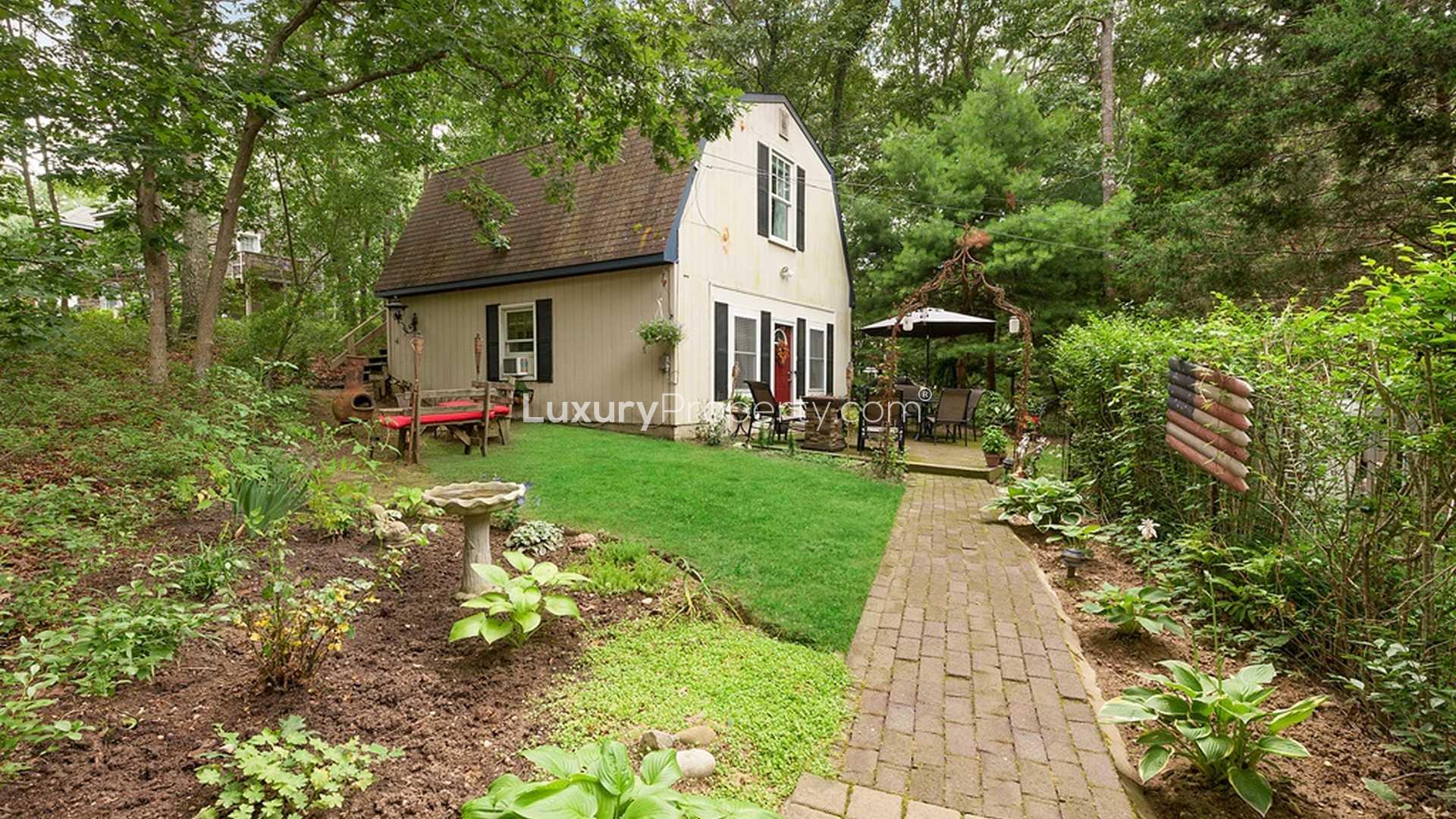 Luxury Hamptons villa backyard with lush garden, deck, and outdoor seating area