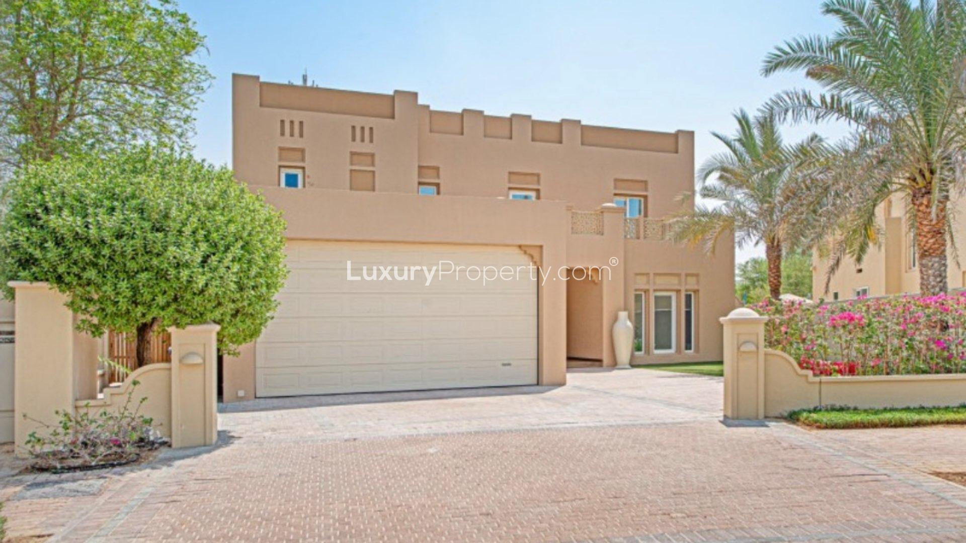 Street view of Al Mahra community in Arabian Ranches, showcasing lush greenery and villas