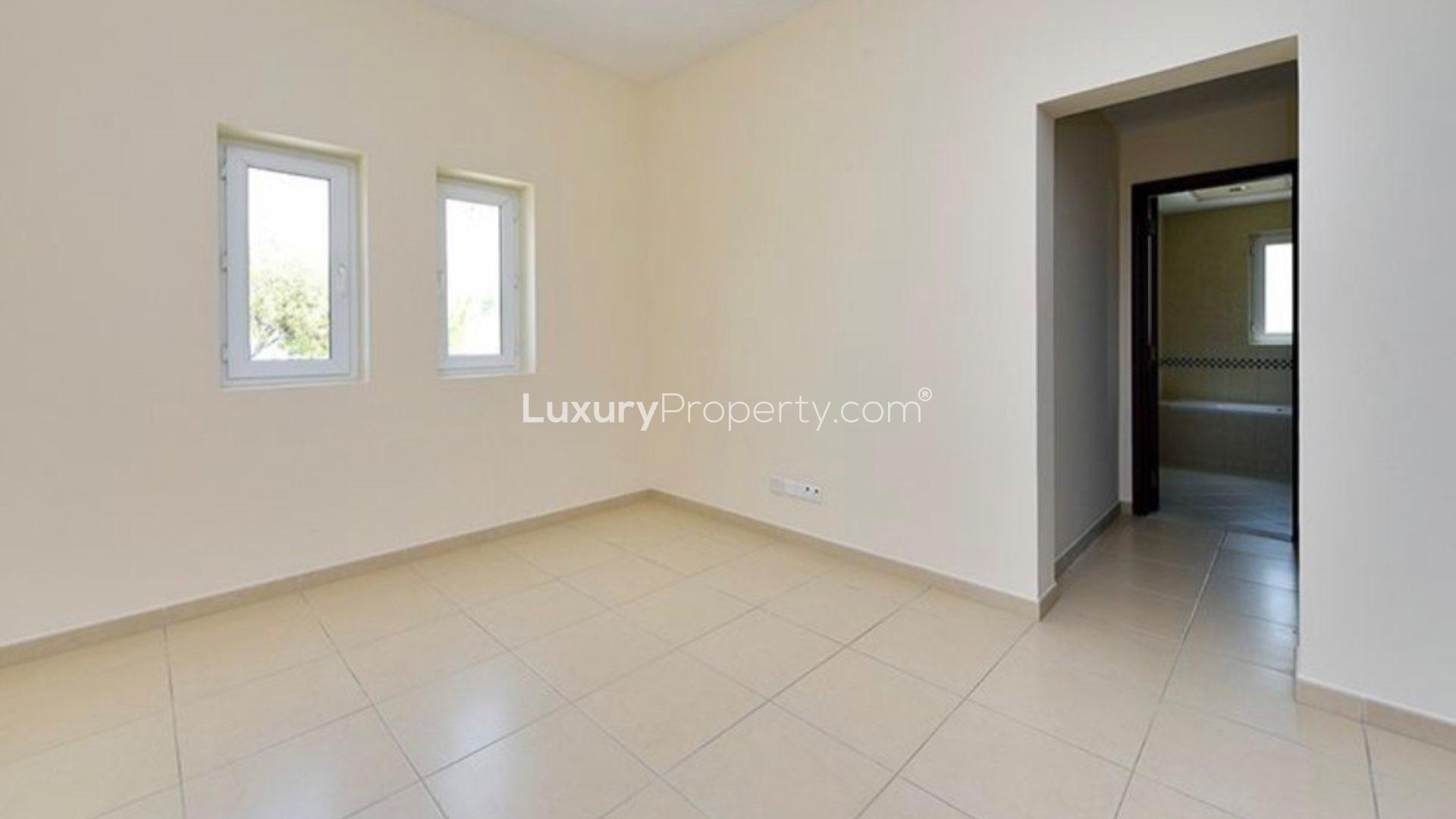 "Spacious living area in 4-bedroom villa, Al Mahra, Arabian Ranches, featuring elegant staircase.",Empty room with tiled floor and two windows in Al Mahra, Arabian Ranches villa