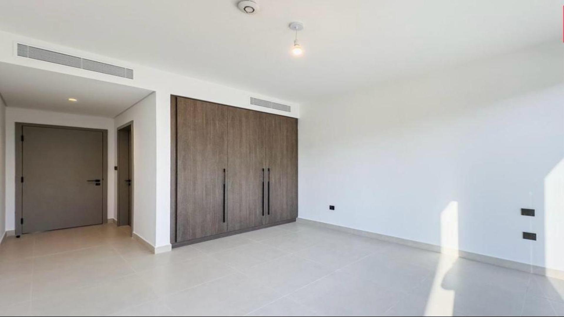 Modern open-plan kitchen and living area in 4-bedroom Aura Villa, Tilal Al Ghaf