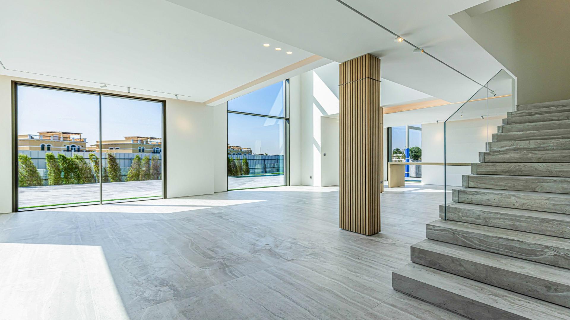 N/A,Modern villa interior with lake view, glass doors, and sleek staircase in Jumeirah Islands