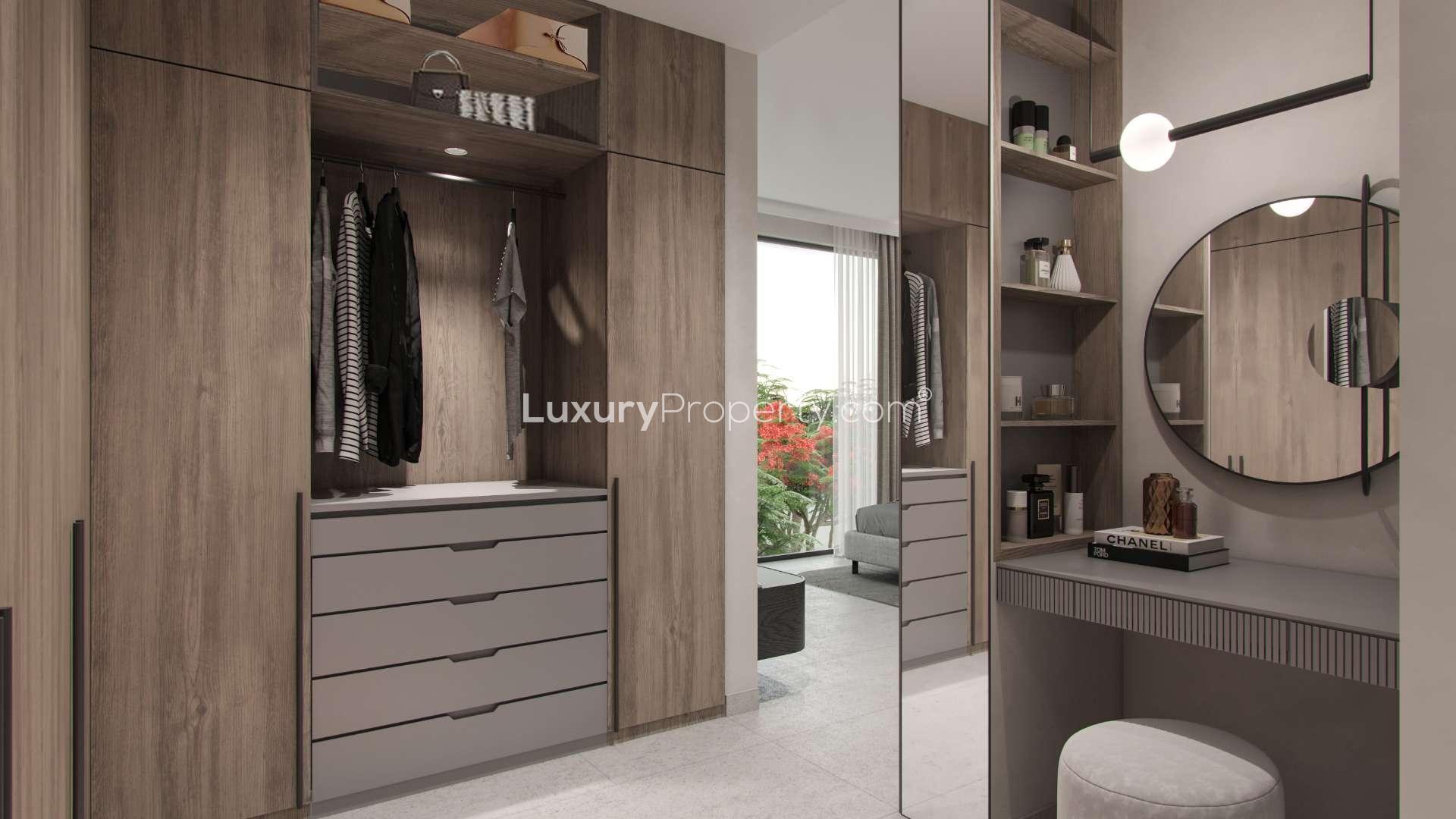 Modern villa exterior in Aura, Tilal Al Ghaf, with lush greenery and luxury cars