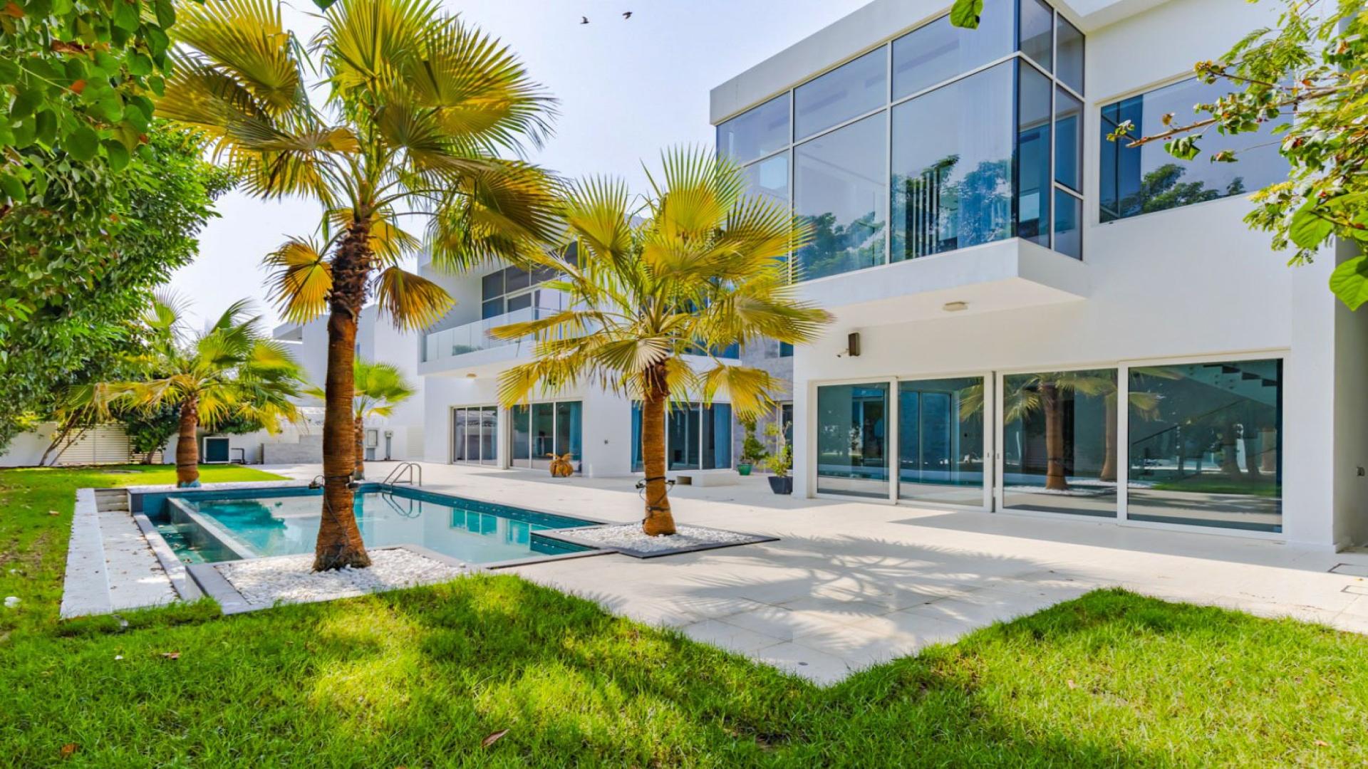 "Spacious patio and lush garden view of luxury villa in The Nest, Al Barari.",Luxury 4-bedroom villa with pool and garden at The Nest, Al Barari for sale