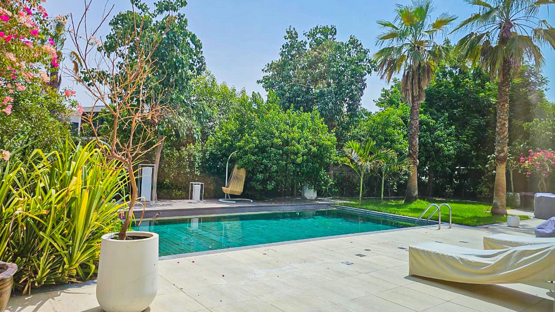 Luxurious living room in The Nest Al Barari villa with modern decor and garden view