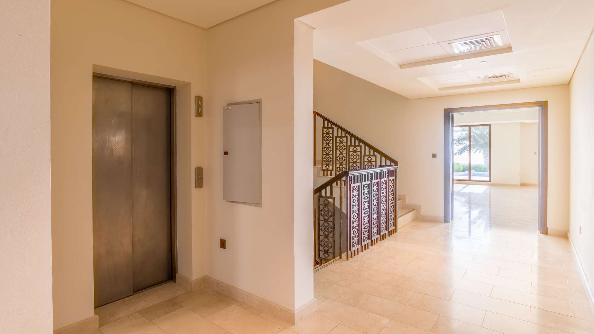 "Elegant villa interior with elevator and staircase in Palm Jumeirah, Kingdom of Sheba.",Empty room with natural light in Palm Jumeirah villa, Kingdom of Sheba, for sale