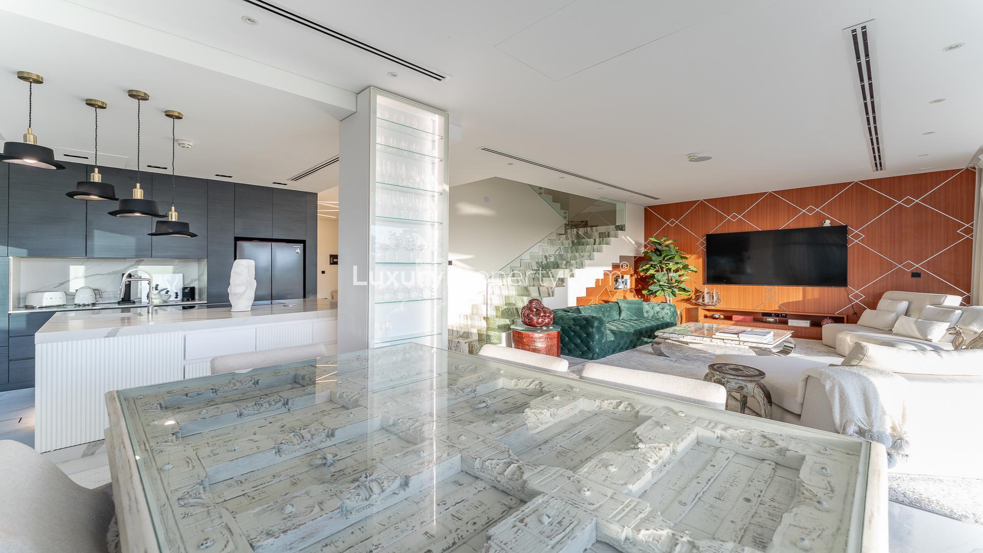 Modern living room in Jumeirah Golf Estates villa with elegant decor and open kitchen