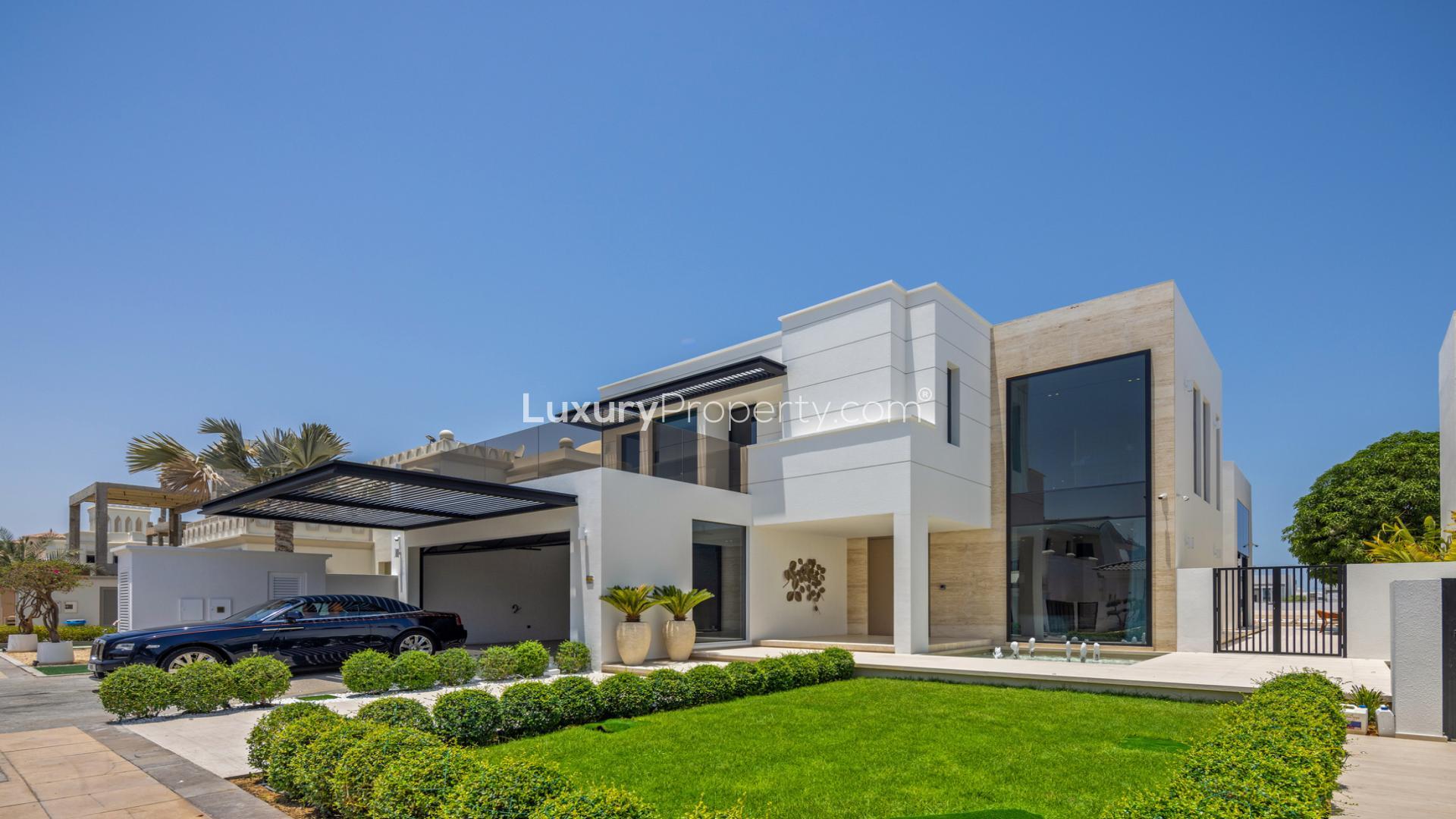 Luxurious Palm Jumeirah villa exterior with modern design, night view, and elegant driveway
