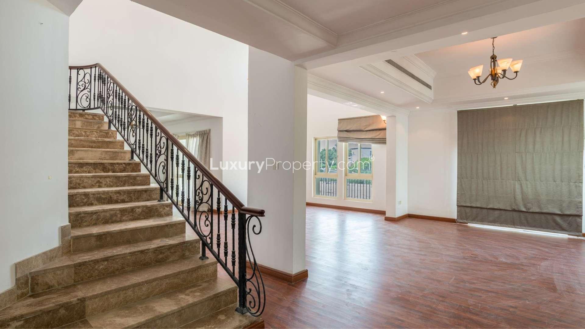 Spacious living area in luxurious Jumeirah Islands villa with wooden flooring and large windows