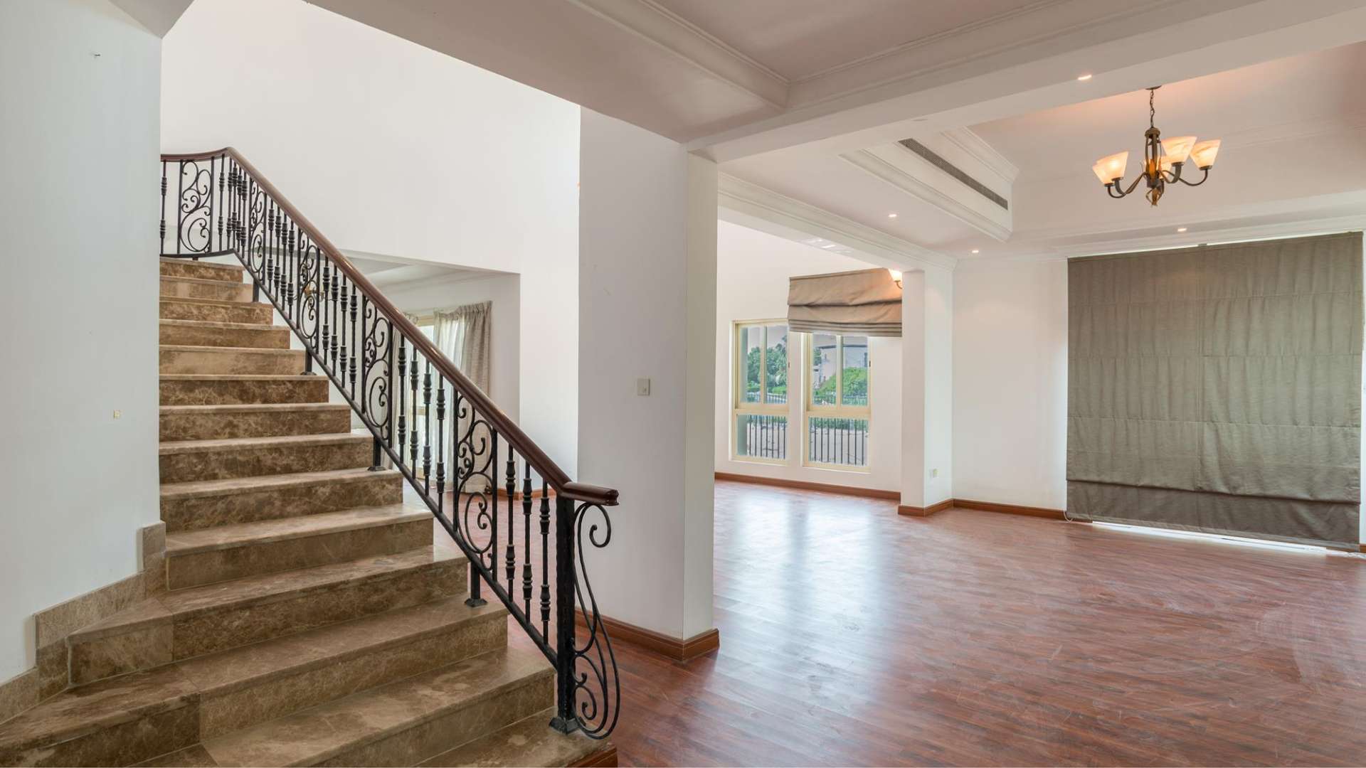 Spacious living area in luxurious Jumeirah Islands villa with wooden flooring and large windows