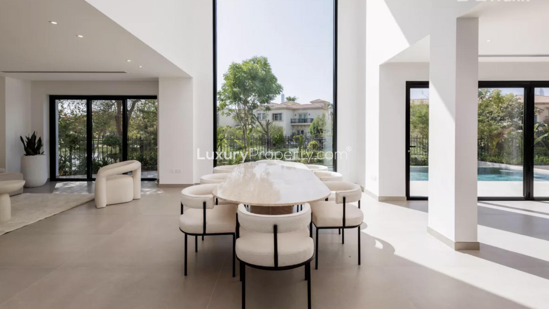 "Spacious modern kitchen with pool view in Jumeirah Islands 4-bedroom villa, Dubai.",Luxurious dining area with pool view in Jumeirah Islands villa, Dubai