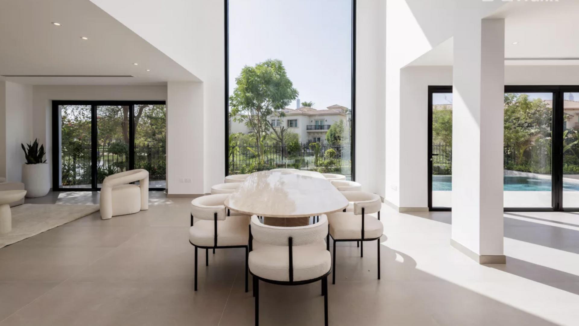 "Spacious modern kitchen with pool view in Jumeirah Islands 4-bedroom villa, Dubai.",Luxurious dining area with pool view in Jumeirah Islands villa, Dubai