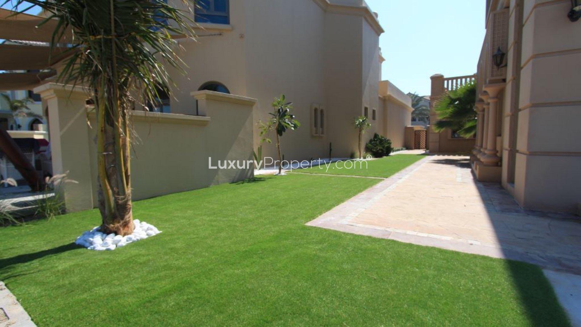 Luxurious Palm Jumeirah villa garden with lush lawn and elegant architecture