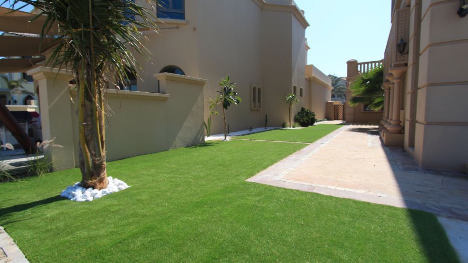 Luxurious Palm Jumeirah villa garden with lush lawn and elegant architecture