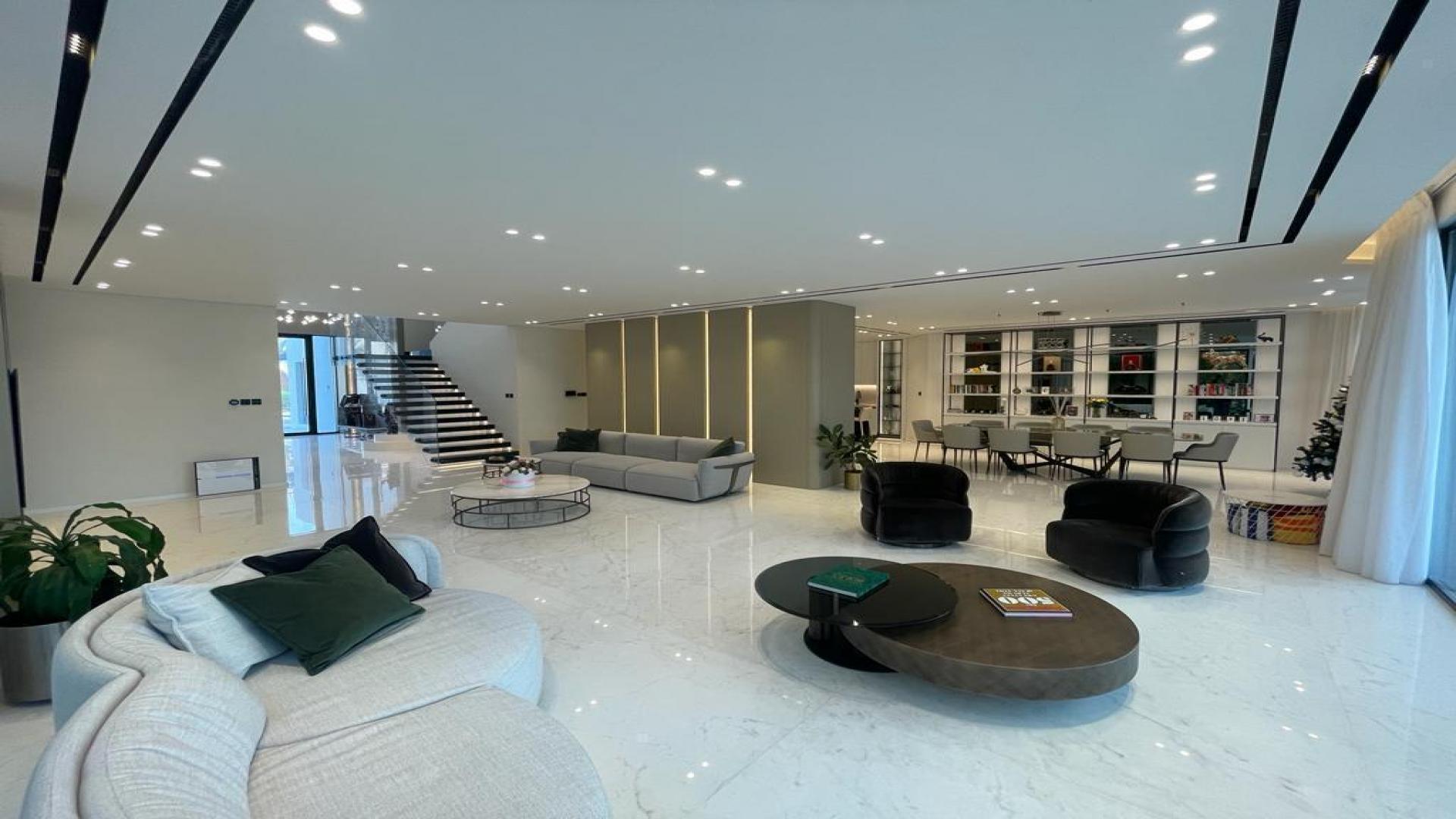 Luxurious open-plan living room in renovated villa, Palm Jumeirah, with modern decor and lighting