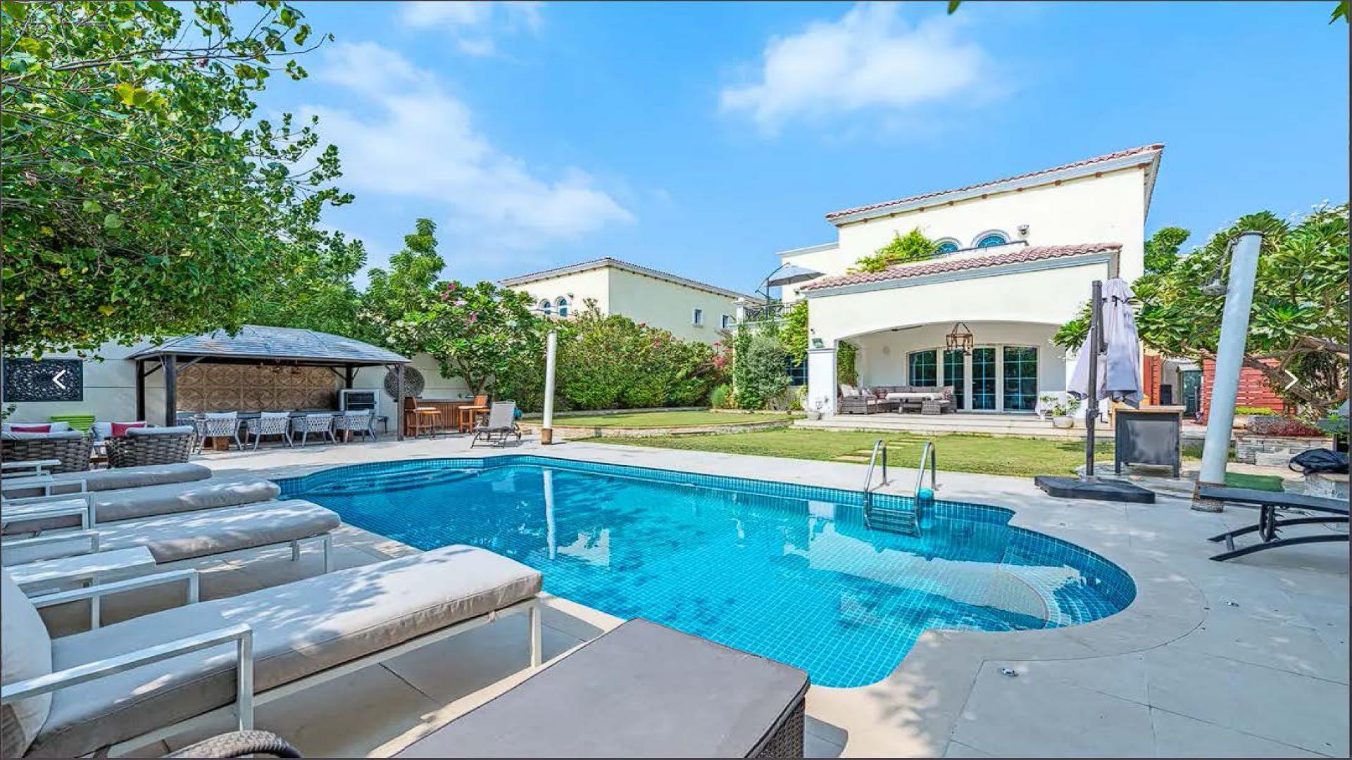 Luxurious living room in 4-bedroom Jumeirah Park Legacy villa, featuring elegant decor and chandeliers